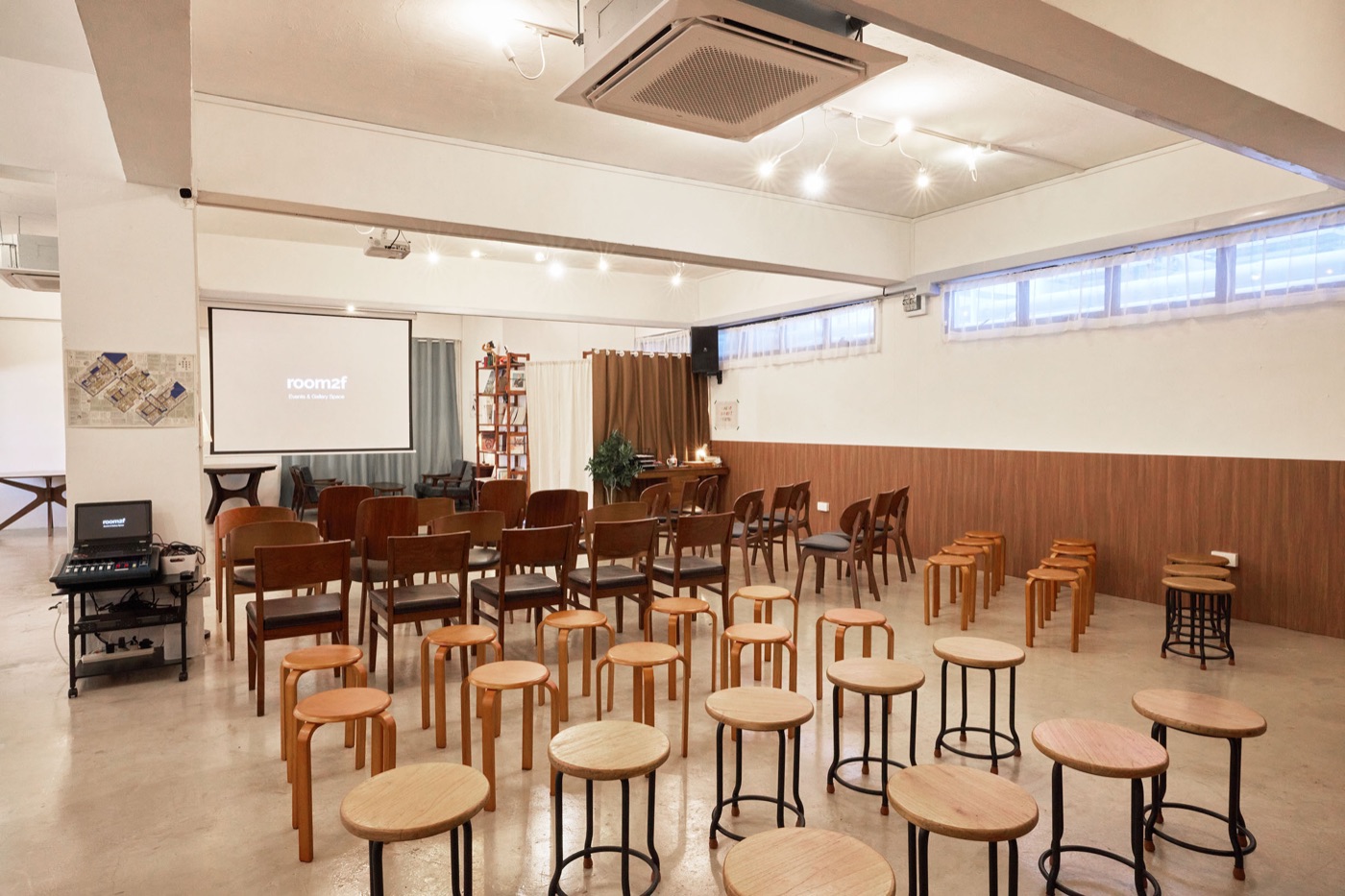Rows of chairs facing a screen at room2f, set up for a workshop.